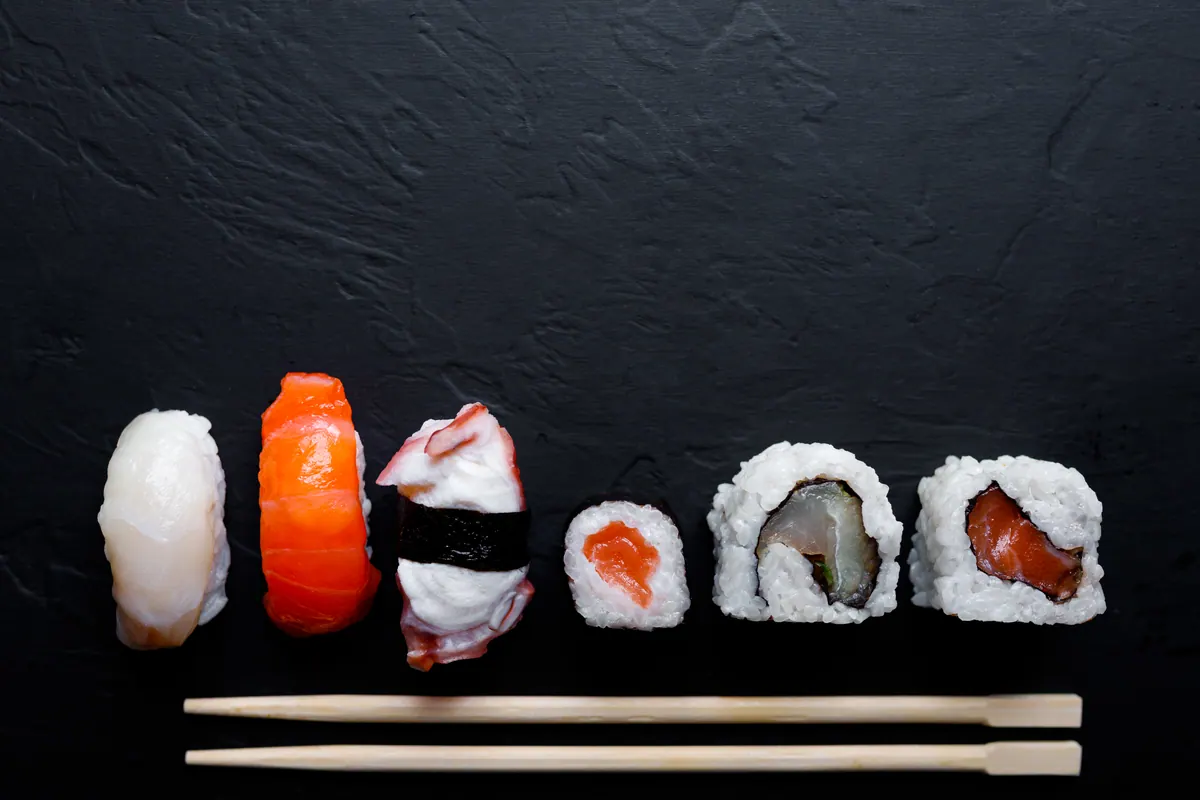 Nigiri and rolls laid out on black stone