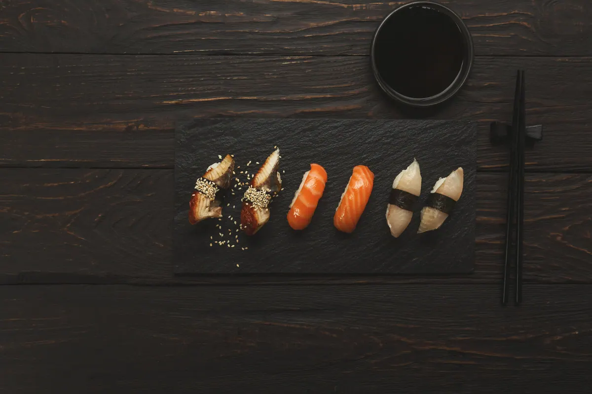Nigiri set out one piece at a time on black wood
